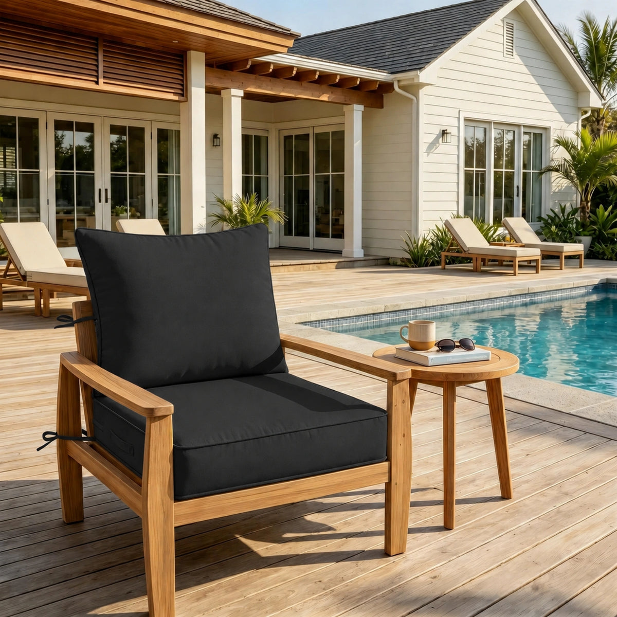 black outdoor deep seat cushion on patio chair with poolside outdoor furniture setting.