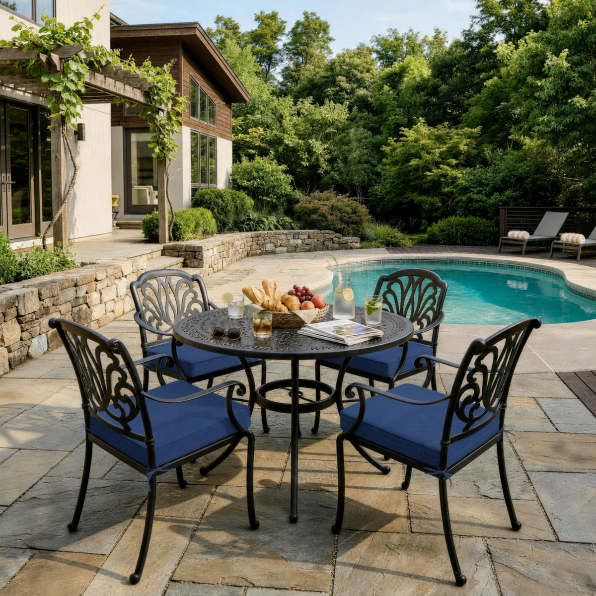 Blue outdoor seat cushions on patio chairs with a round outdoor dining table in a backyard setting.