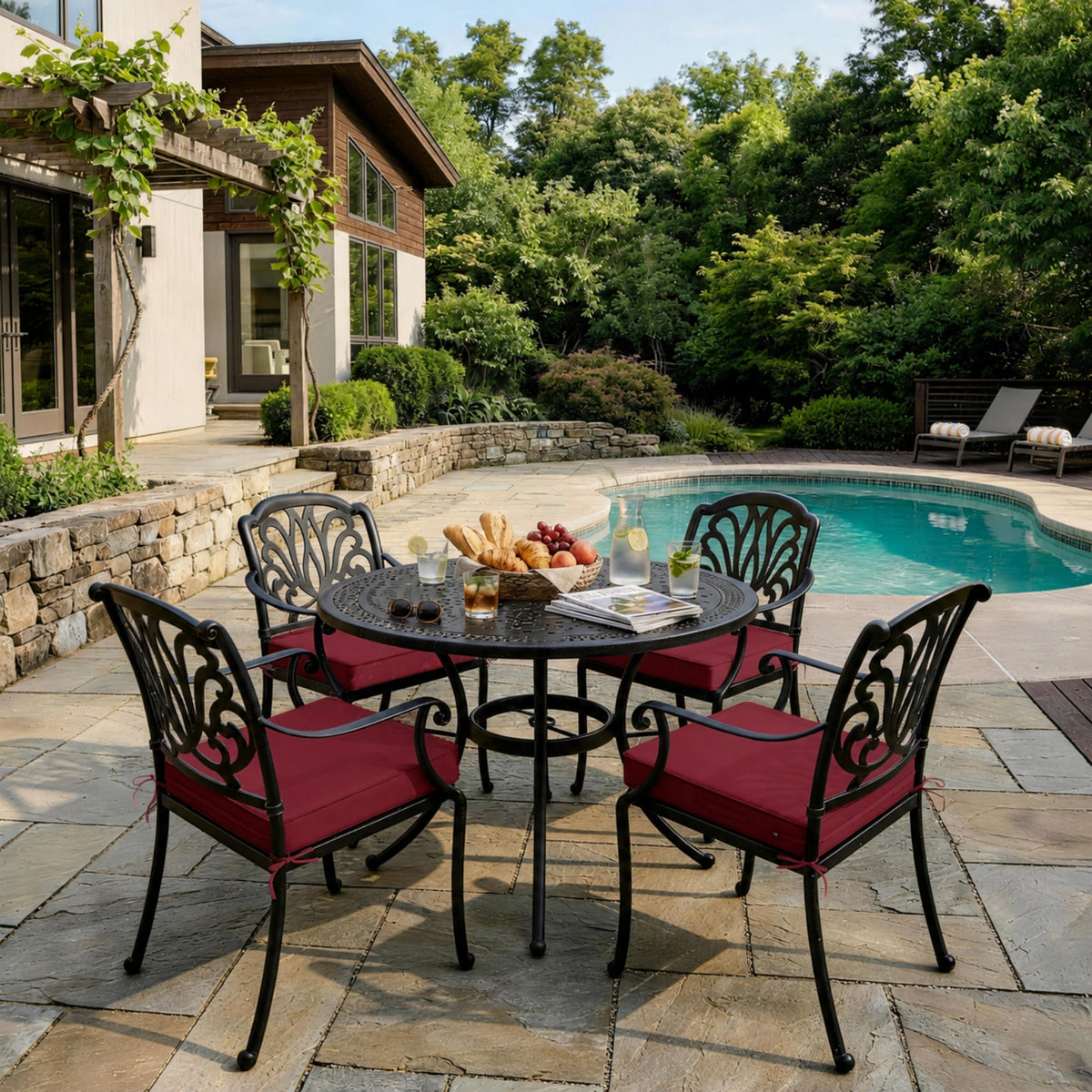 Burgundy outdoor seat cushions on patio chairs with a round outdoor dining table in a backyard setting.
