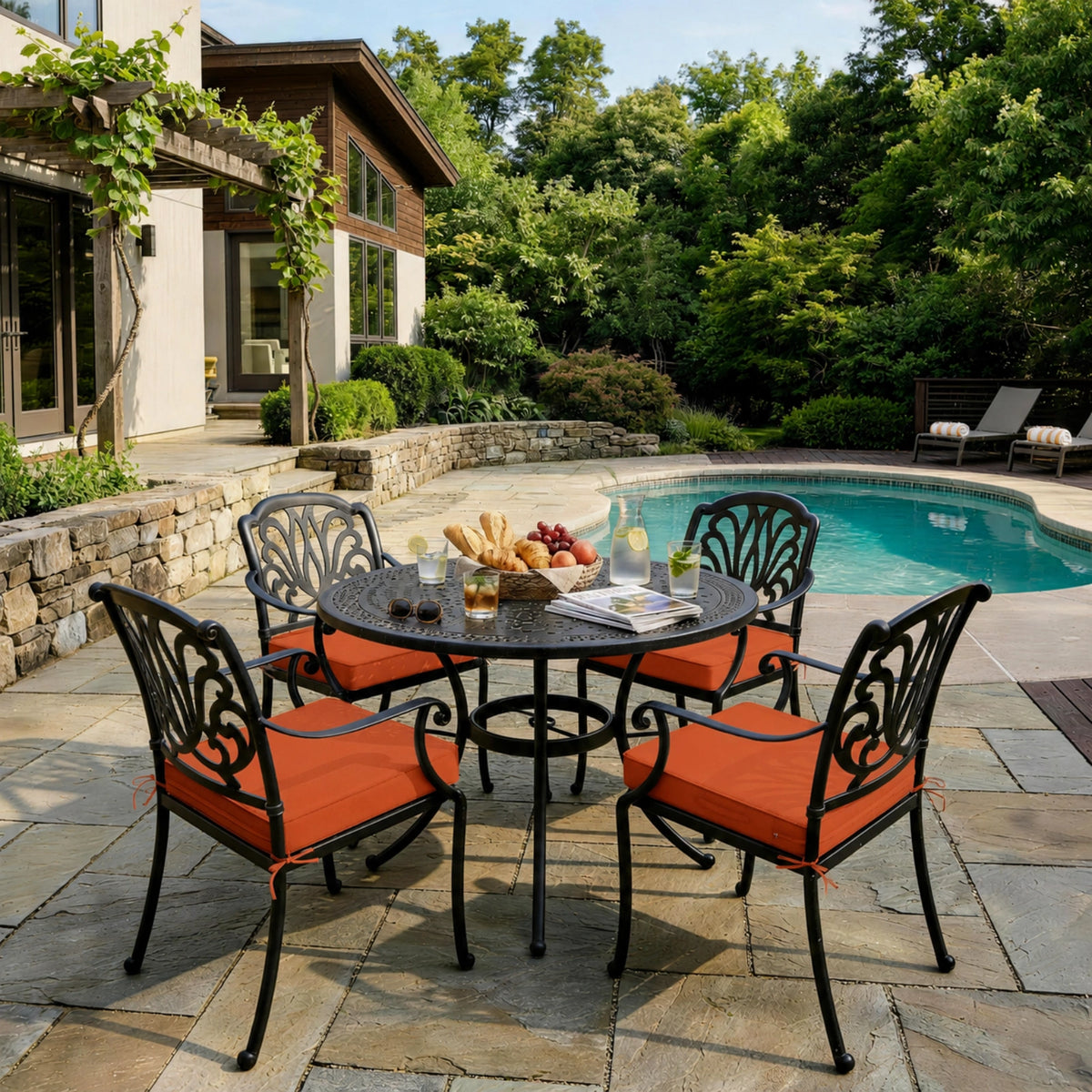 Orange Red outdoor seat cushions on patio chairs with a round outdoor dining table in a backyard setting.