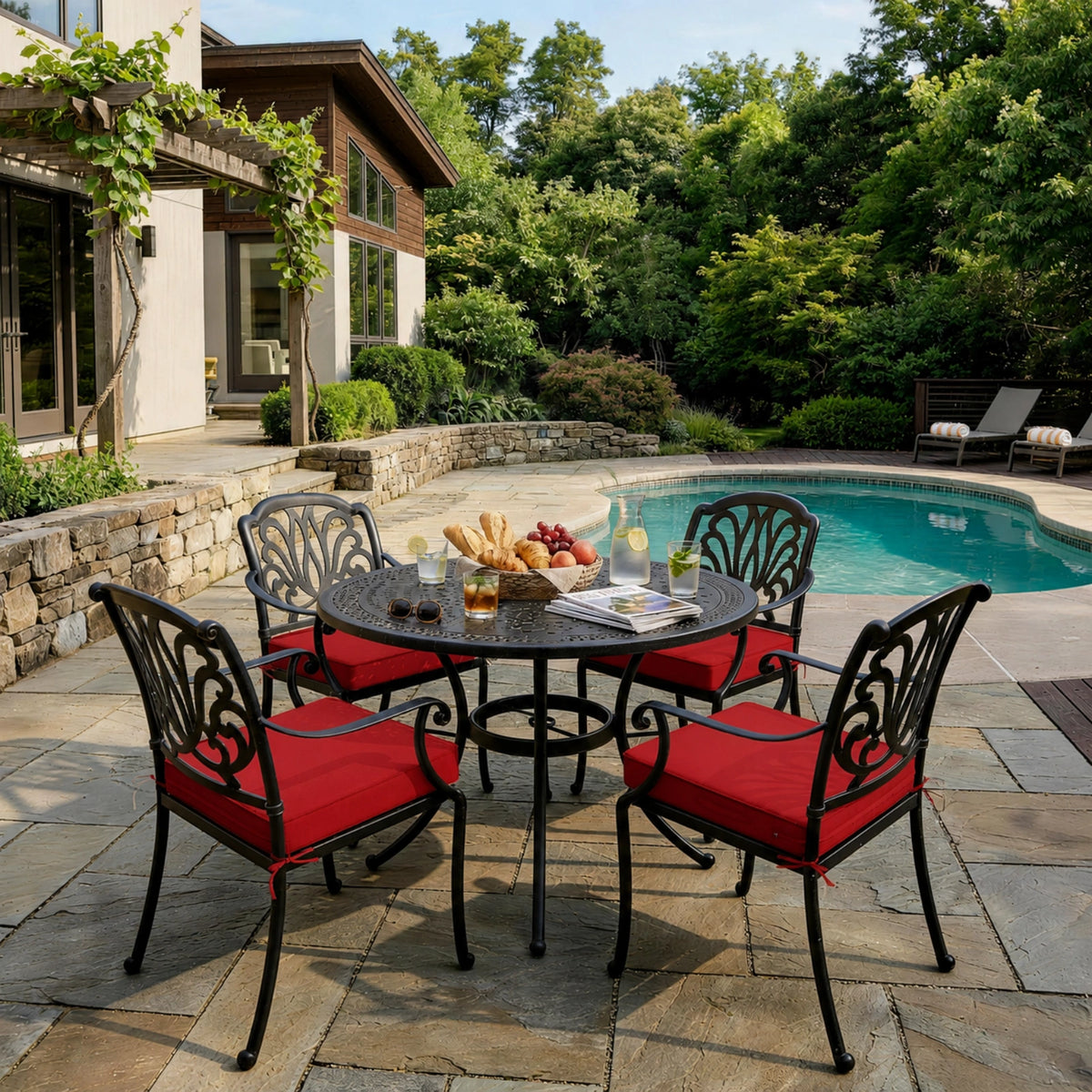 Red outdoor seat cushions on patio chairs with a round outdoor dining table in a backyard setting.