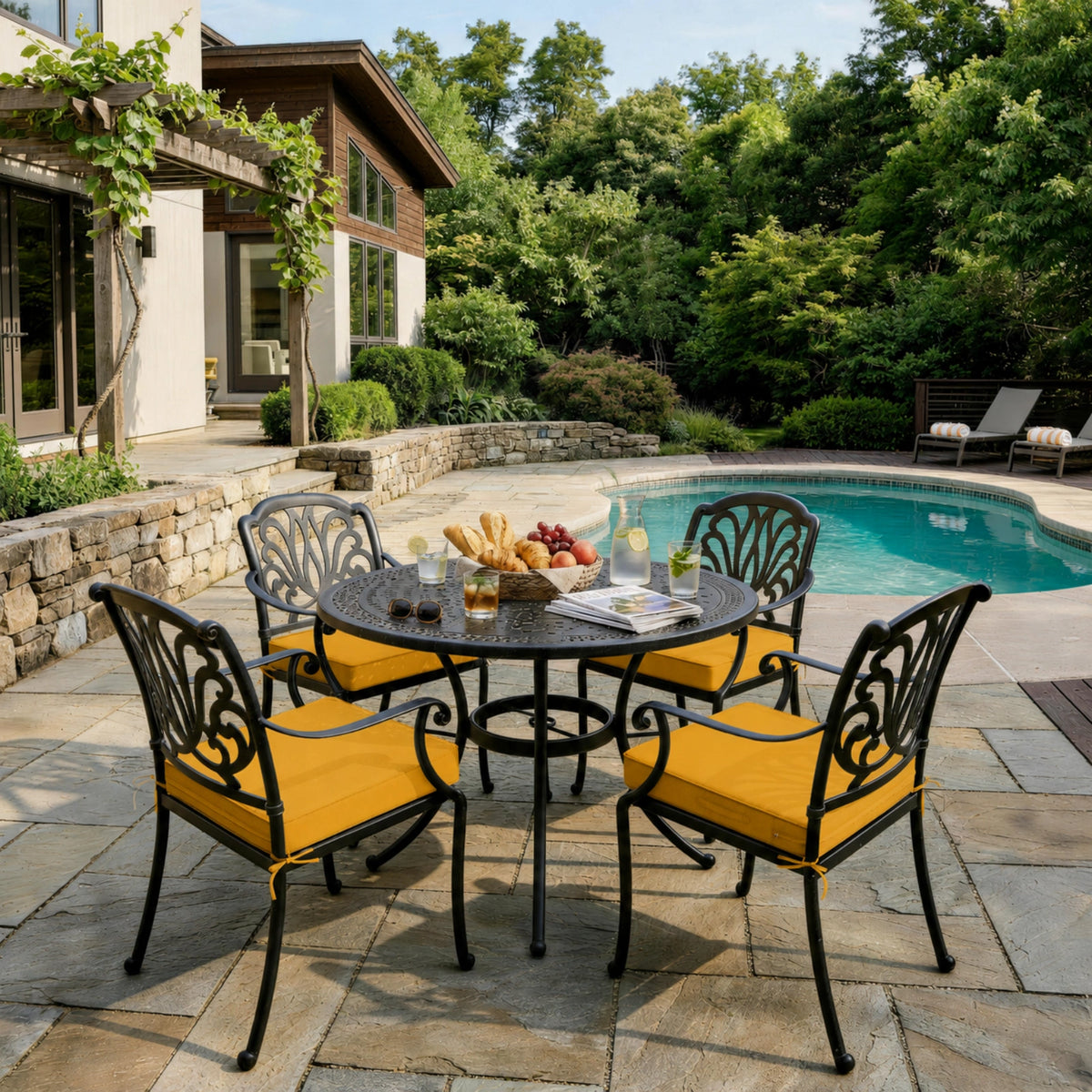 Yellow outdoor seat cushions on patio chairs with a round outdoor dining table in a backyard setting.