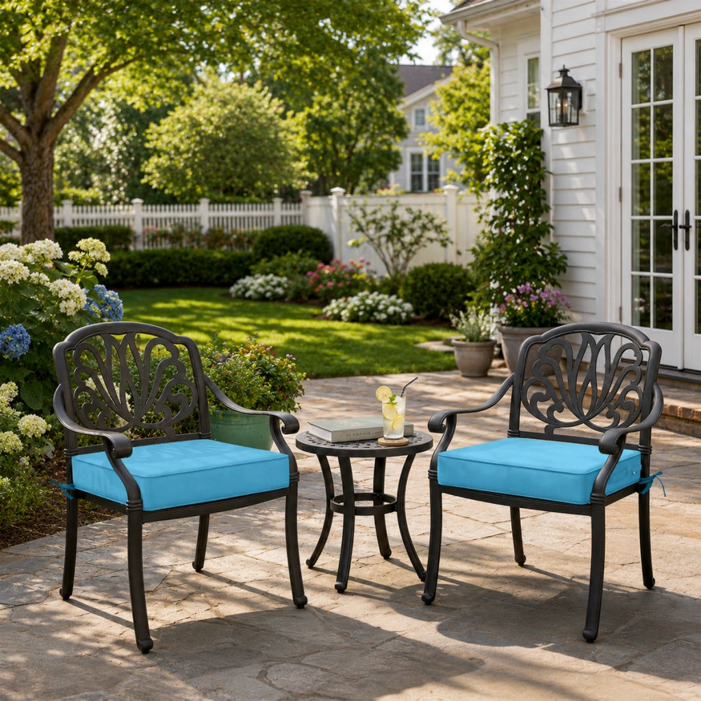 outdoor seat cushions in bright blue on black metal patio chairs, styled in a sunny backyard garden with a small outdoor side table
