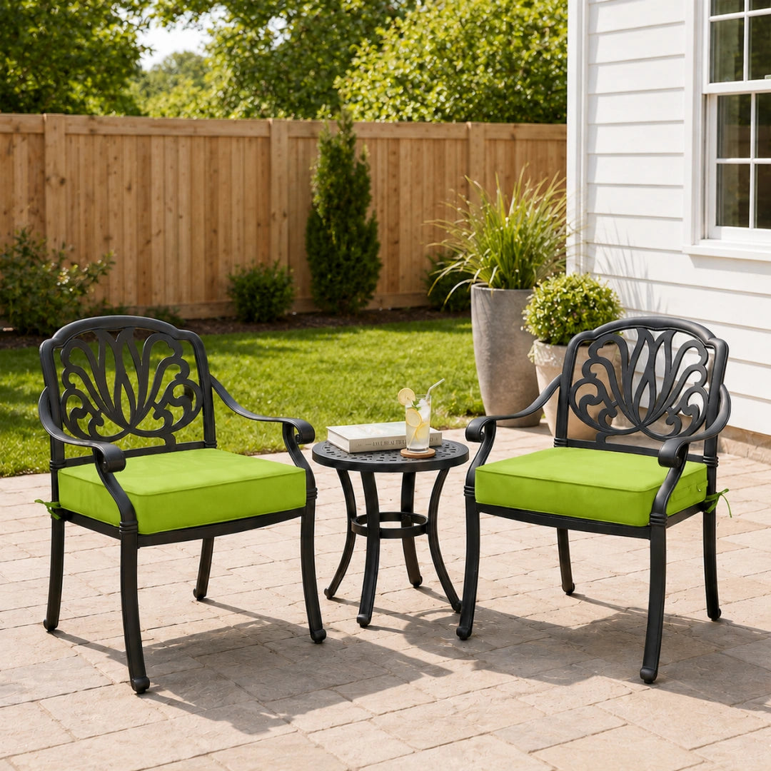 outdoor seat cushions in grass green on black metal patio chairs, styled in a sunny backyard garden with a small outdoor side table