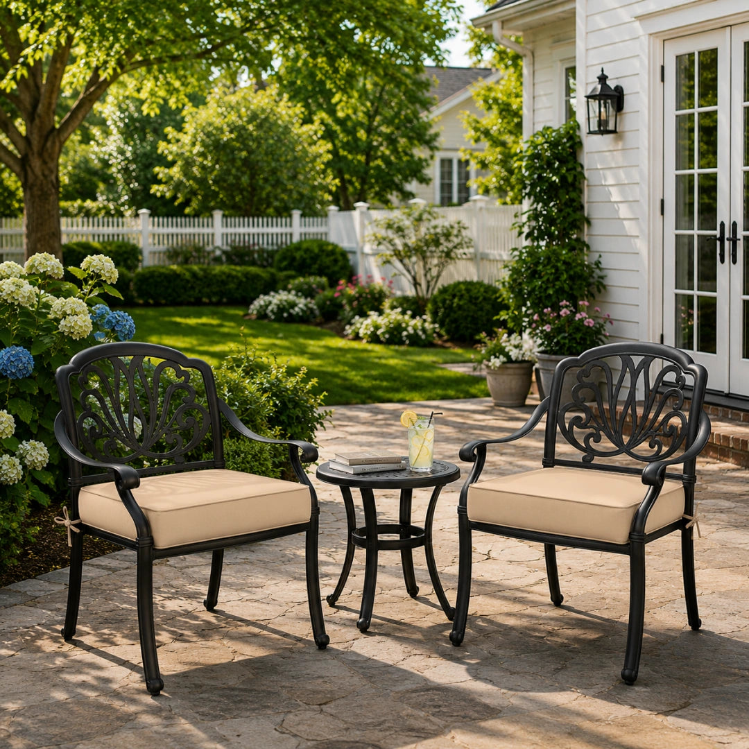 outdoor seat cushions in beige on black metal patio chairs, styled in a sunny backyard garden with a small round outdoor table