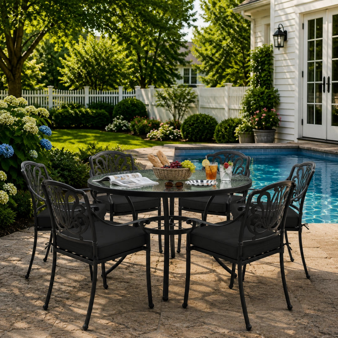 outdoor seat cushions in black on black metal patio chairs, styled in a sunny backyard garden with a small round outdoor table