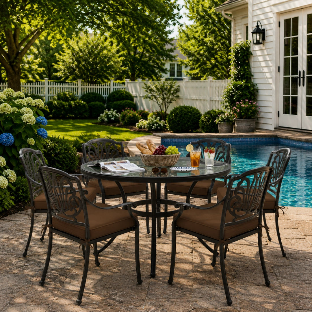 outdoor seat cushions in brown on black metal patio chairs, styled in a sunny backyard garden with a small round outdoor table