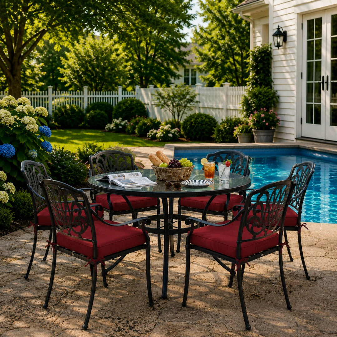 outdoor seat cushions in burgundy red on black metal patio chairs, styled in a sunny backyard garden with a small round outdoor table