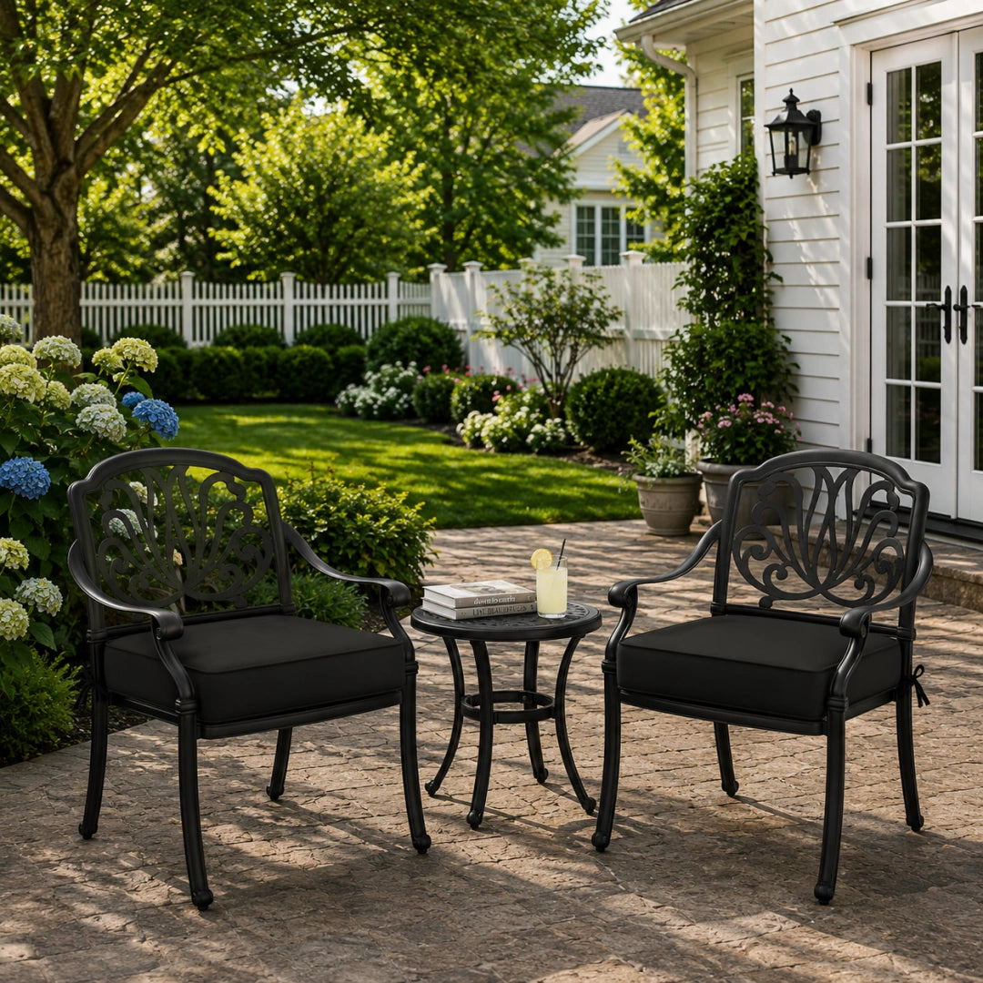 outdoor seat cushions clearance style in black, shown on two metal patio chairs in a backyard outdoor seating area