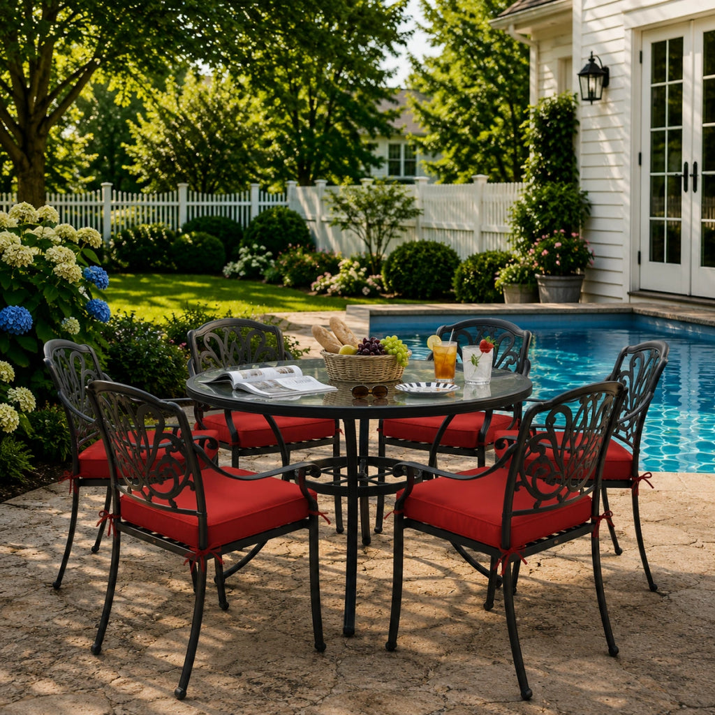 outdoor seat cushions in crimson red on black metal patio chairs, styled in a sunny backyard garden with a small round outdoor table