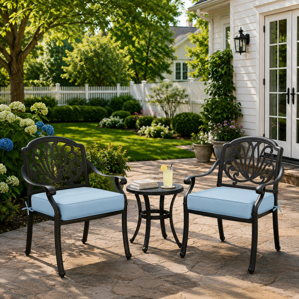 outdoor seat cushions for chairs in light blue on black metal patio chairs, styled beside a small outdoor table