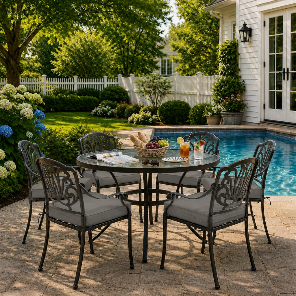 outdoor seat cushions in gray on black metal patio chairs, styled in a sunny backyard garden with a small round outdoor table