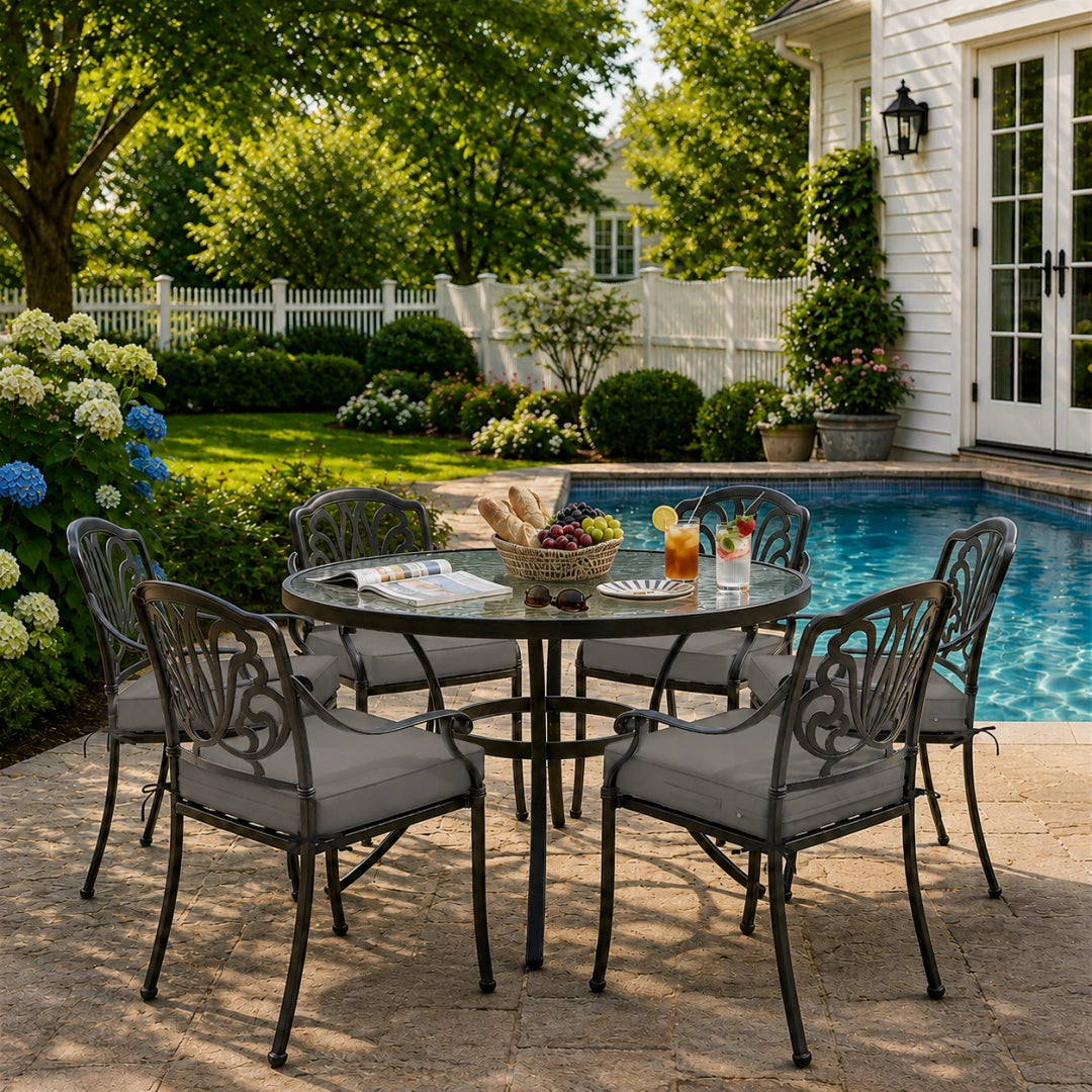 outdoor seat cushions in gray on black metal patio chairs, styled in a sunny backyard garden with a small round outdoor table