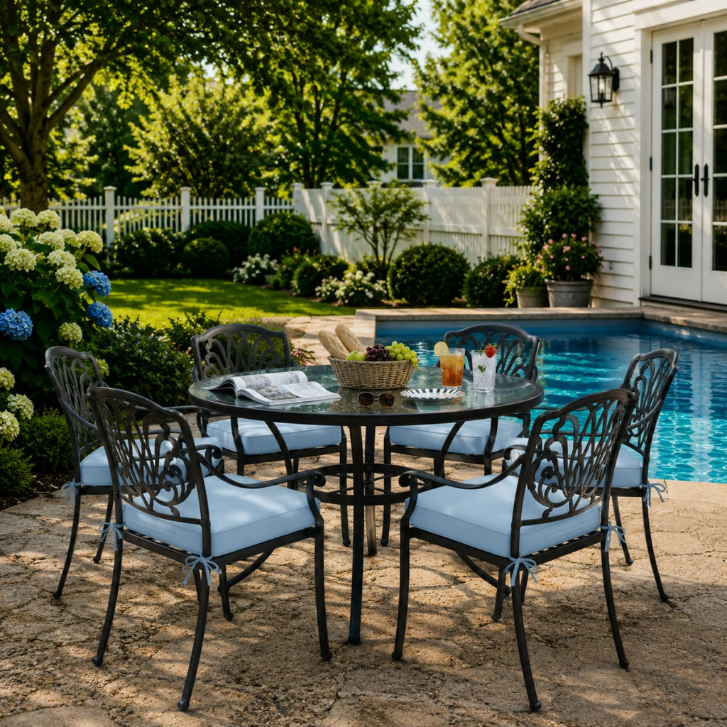 outdoor seat cushions in light blue on black metal patio chairs, styled in a sunny backyard garden with a small round outdoor table
