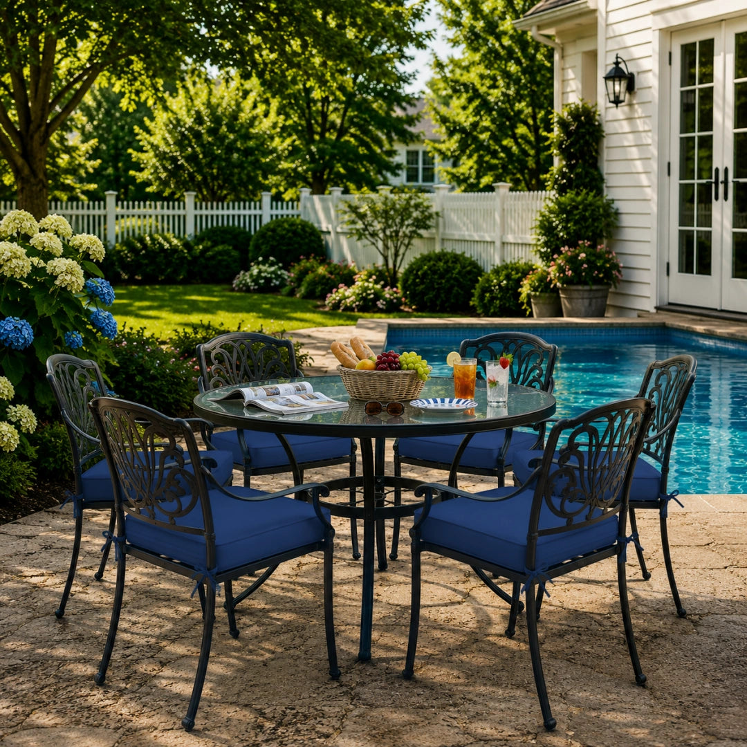 outdoor seat cushions in navy blue on black metal patio chairs, styled in a sunny backyard garden with a small round outdoor table