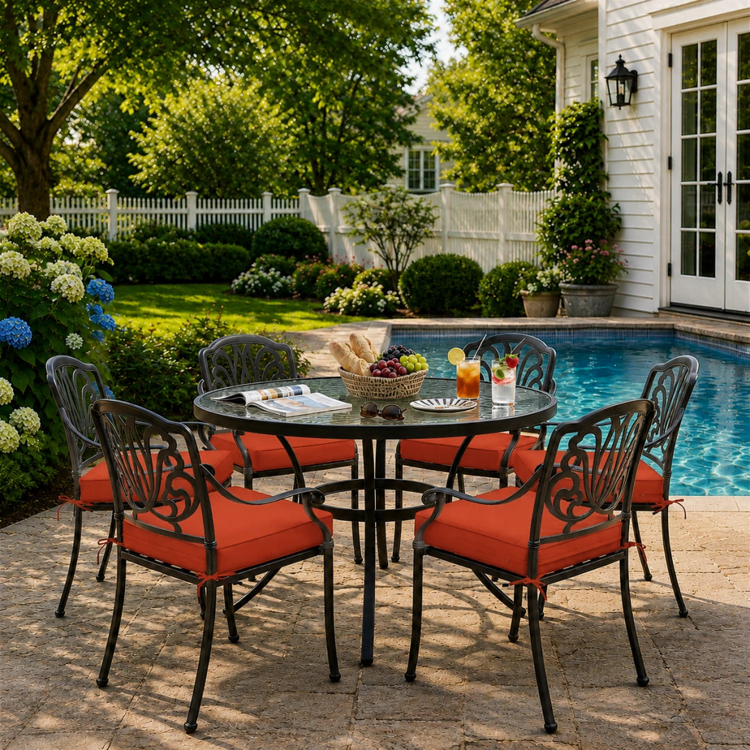 outdoor seat cushions in orange on black metal patio chairs, styled in a sunny backyard garden with a small round outdoor table