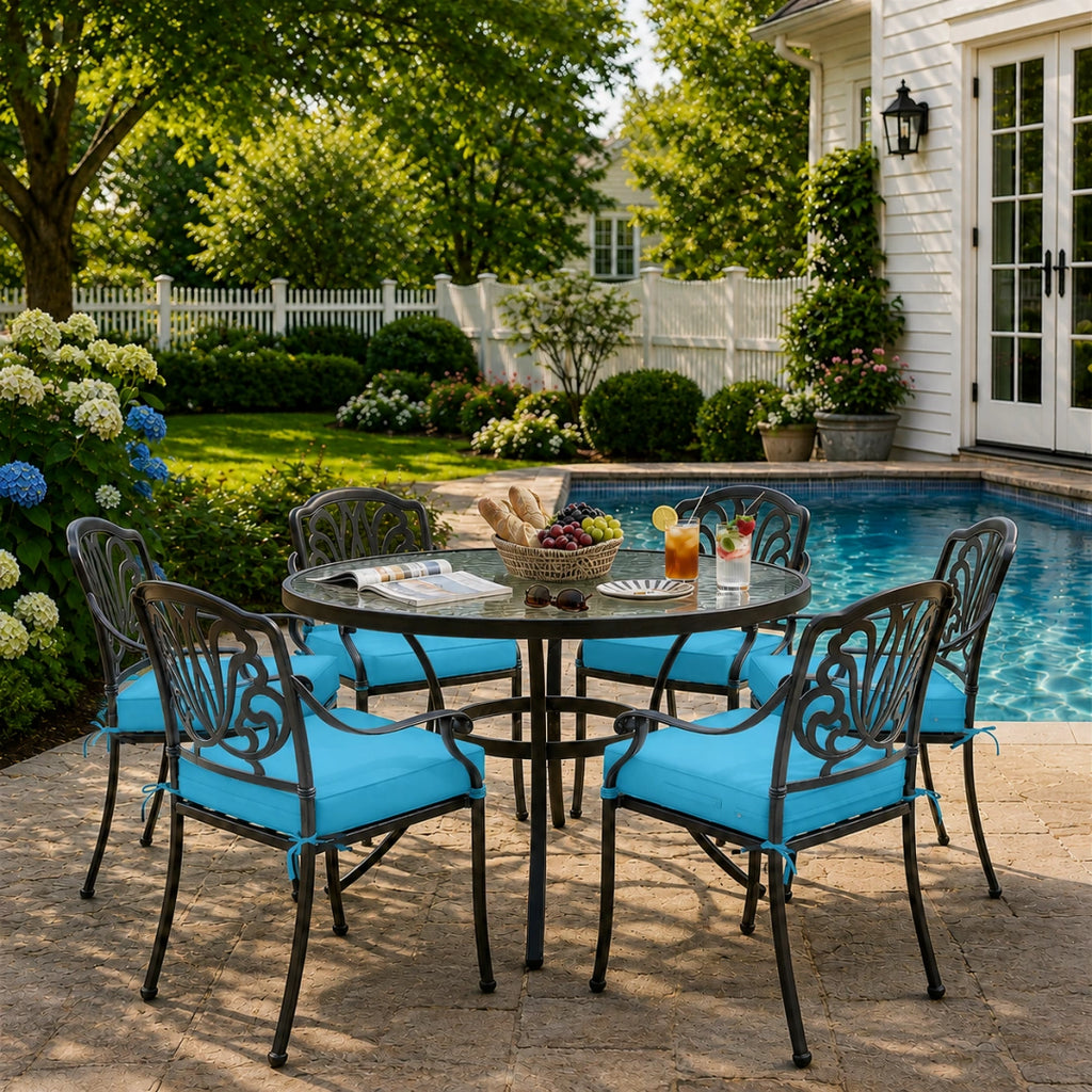 outdoor seat cushions in turquoise on black metal patio chairs, styled in a sunny backyard garden with a small round outdoor table